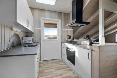 a kitchen with white appliances and wooden walls at 205-Harboore-Doblervej-39 in Harboør