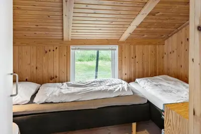 two beds in a wooden room with a window at 202-Harboore-Viktoriavej-12-a in Harboør