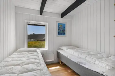 two beds in a white room with a window at 301-Harboore-Themisvej-11 in Harboør