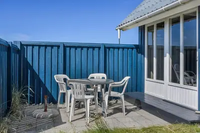 a table and chairs on the deck of a tiny house at 301-Harboore-Themisvej-11 in Harboør