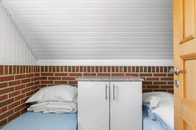 a small room with a bed and a brick wall at G149-Lemvig-Porsevej-49 in Lemvig