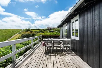 a wooden deck with chairs and a table on it at G398-Lemvig-Violvej-98 in Lemvig