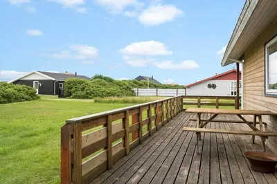 a wooden deck with a picnic table on it at 294-Harboore-Neerlandiavej-102 in Harboør