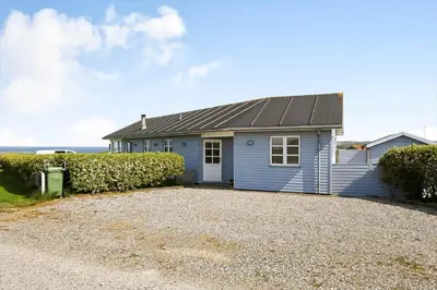 a blue house with a gravel driveway at G287-Lemvig-Bellisvej-87 in Lemvig