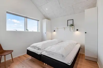 a white bedroom with a bed and a window at 350-Harboore-Alkajavej-13-A in Harboør