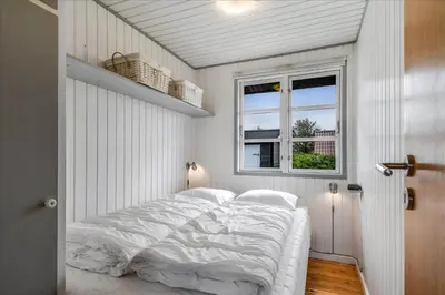 a white bedroom with a large bed with a window at 251-Harboore-Neerlandiavej-230 in Harboør