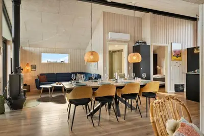 a dining room and living room with a table and chairs at 332-Harboore-Hvilehjemsvej-20 in Harboør
