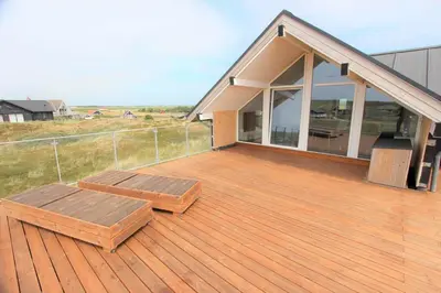 a deck with two benches on top of a house at 257-Harboore-Dalevej-8 in Harboør