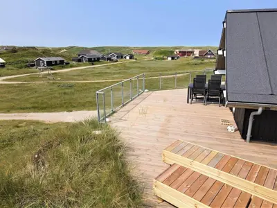 a wooden deck with chairs sitting on top of a house at 257-Harboore-Dalevej-8 in Harboør