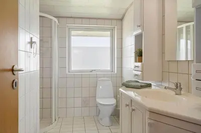 a bathroom with a toilet and a sink and a window at G249-Lemvig-Bellisvej-49 in Lemvig
