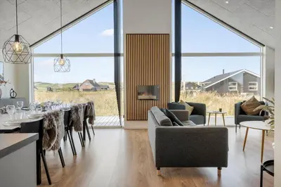 a dining room with tables and chairs and large windows at 360-Harboore-Alkajavej-11 in Harboør