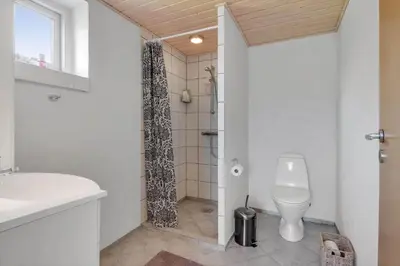 a white bathroom with a toilet and a shower at G129-Lemvig-Gjelleroddevej-129 in Lemvig
