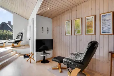 a living room with a chair and a television at G129-Lemvig-Gjelleroddevej-129 in Lemvig
