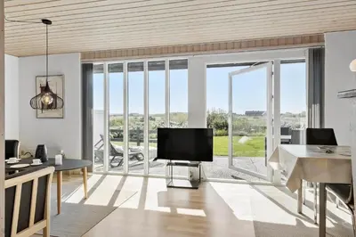 a living room with a tv and a large window at 114-Harboore-Strandvejen-164 in Harboør