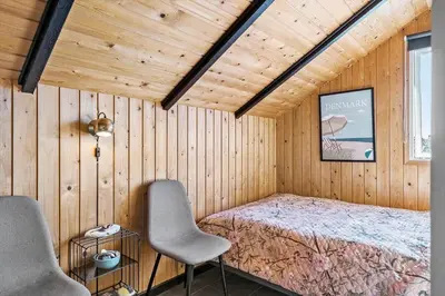 a bedroom with a bed and two chairs in a room at 127-Harboore-Vejlby-Klit-237 in Harboør