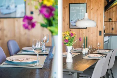 a dining room table with glasses of wine and flowers at 127-Harboore-Vejlby-Klit-237 in Harboør