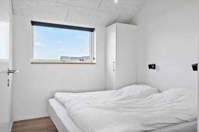 a white bedroom with a bed and a window at 252-Harboore-Amazonevej-6 in Harboør