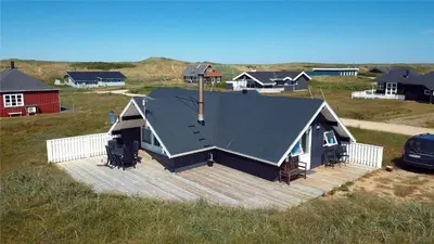 a house with a large deck in a field at 318-Harboore-Charlottevej-9 in Harboør