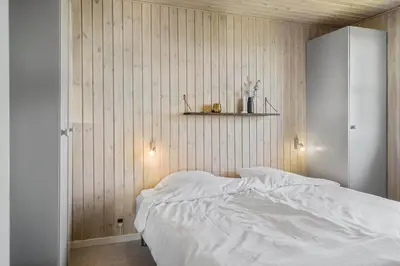 a bedroom with a white bed and a shelf at G319-Lemvig-Violvej-19 in Lemvig