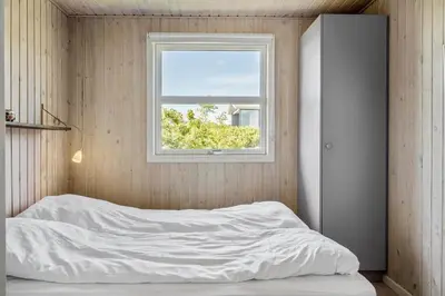 a bedroom with a white bed and a window at G319-Lemvig-Violvej-19 in Lemvig