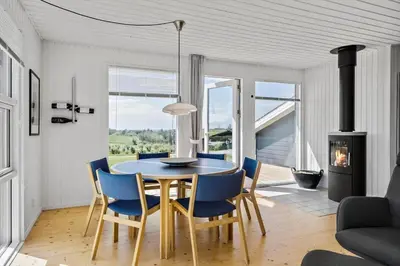 a dining room with a table and chairs and a fireplace at G219-Lemvig-Skovstjernevej-19 in Lemvig