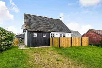 a black and white house with a wooden fence at 715-Thyboron-Limfjordsvej-17-a in Thyborøn