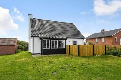 a white house with a fence in a yard at 715-Thyboron-Limfjordsvej-17-a in Thyborøn