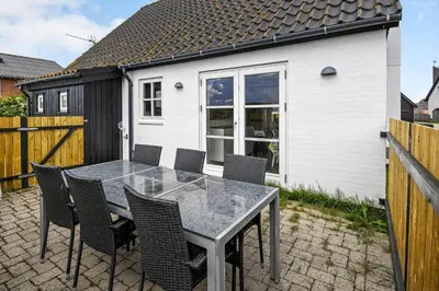 a table and chairs on a patio with a house at 715-Thyboron-Limfjordsvej-17-a in Thyborøn