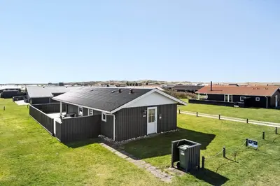 a house with a pitched roof on a grass field at 182-Harboore-Vejlby-Klit-153-a in Harboør