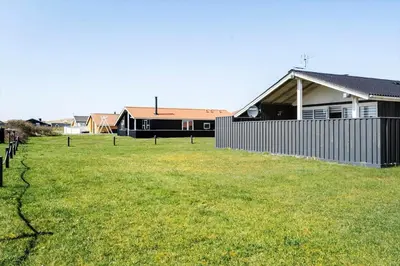 a yard with a fence in front of a house at 182-Harboore-Vejlby-Klit-153-a in Harboør