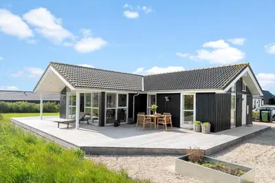 a house with a deck with a table at G126-Lemvig-Bynkevej-26 in Lemvig