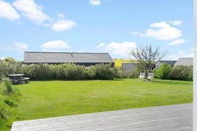 a lawn with two benches and a building in the background at G126-Lemvig-Bynkevej-26 in Lemvig