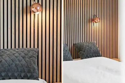 a bedroom with two chairs and a bed and a wall at 204-Harboore-Vejlby-Klit-33 in Harboør