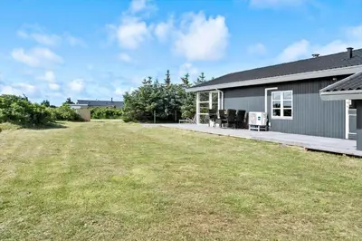a house with a yard next to a building at 204-Harboore-Vejlby-Klit-33 in Harboør