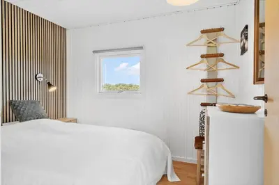 a white bedroom with a bed and a window at 204-Harboore-Vejlby-Klit-33 in Harboør