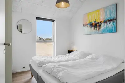 a white bed in a room with a painting on the wall at 368-Harboore-Gloryvej-25 in Harboør