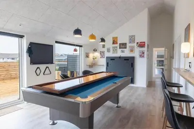 a pool table in a room with chairs and a tv at 368-Harboore-Gloryvej-25 in Harboør