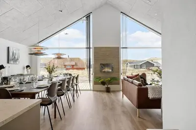 a dining room with a long table and chairs at 368-Harboore-Gloryvej-25 in Harboør