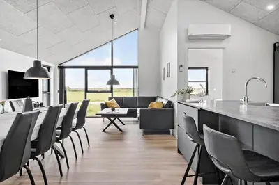 a kitchen and living room with a table and chairs at 260-Harboore-Strandvejen-158-C in Harboør