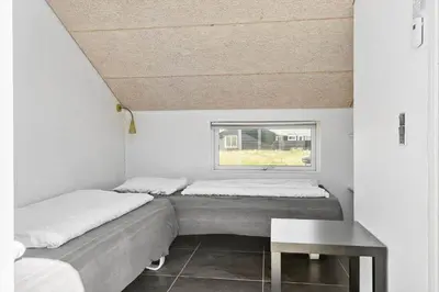 two beds in a small room with a window at 148-Harboore-Lucievej-6-a in Harboør