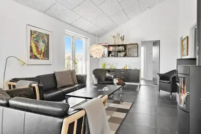 a living room with a couch and a table at 148-Harboore-Lucievej-6-a in Harboør