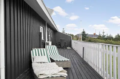 two green and white chairs sitting on a deck at 281-Harboore-Vejlby-Klit-27 in Harboør