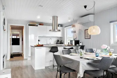 a kitchen and dining room with a table and chairs at 281-Harboore-Vejlby-Klit-27 in Harboør