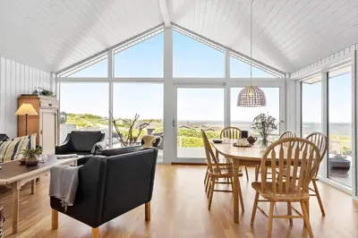 a living room with a table and chairs and a large window at G302-Lemvig-Skovstjernevej-2 in Lemvig