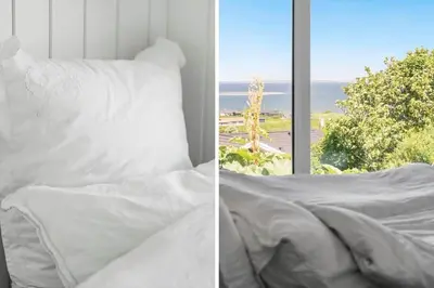 a white bed with a view of the ocean at G302-Lemvig-Skovstjernevej-2 in Lemvig