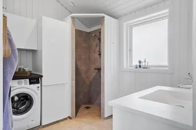 a white bathroom with a washing machine and a sink at G302-Lemvig-Skovstjernevej-2 in Lemvig