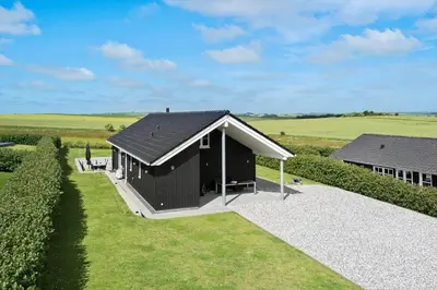 a black building with a roof on a field at G509-Lemvig-Myntevej-9 in Lemvig