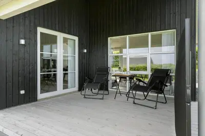 a patio with chairs and a table and windows at G509-Lemvig-Myntevej-9 in Lemvig