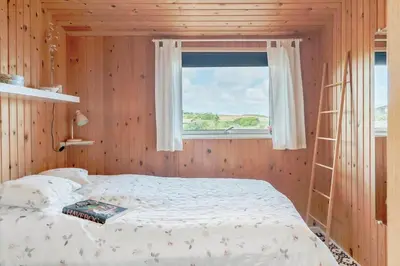 a bedroom with a bed with a ladder and a window at G192-Lemvig-Violvej-92 in Lemvig
