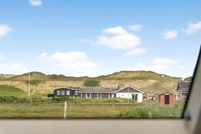 a view of a house with mountains in the background at 324-Harboore-Skalvej-4-b in Harboør